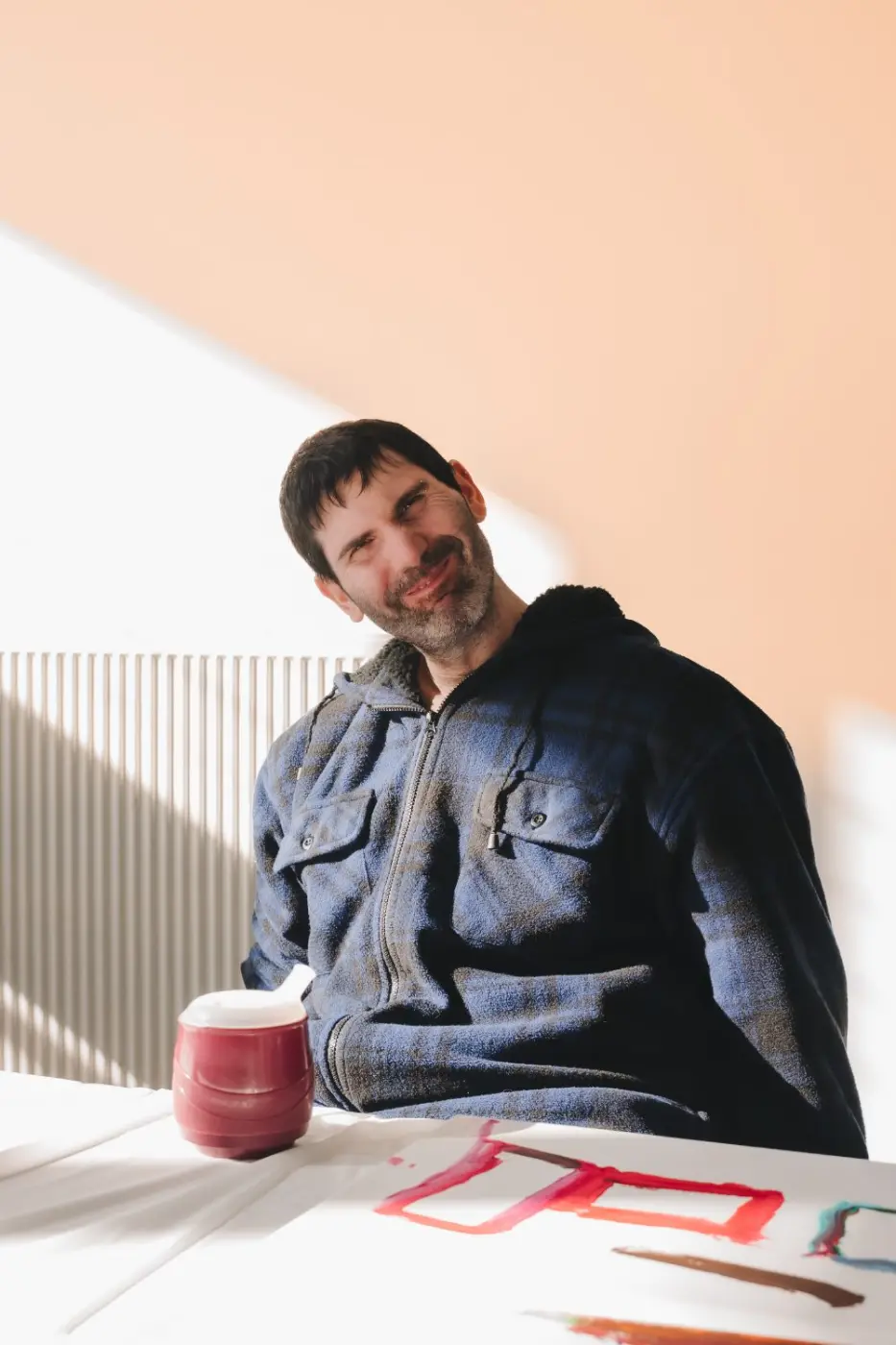 Participant smiling at a table during a group art activity