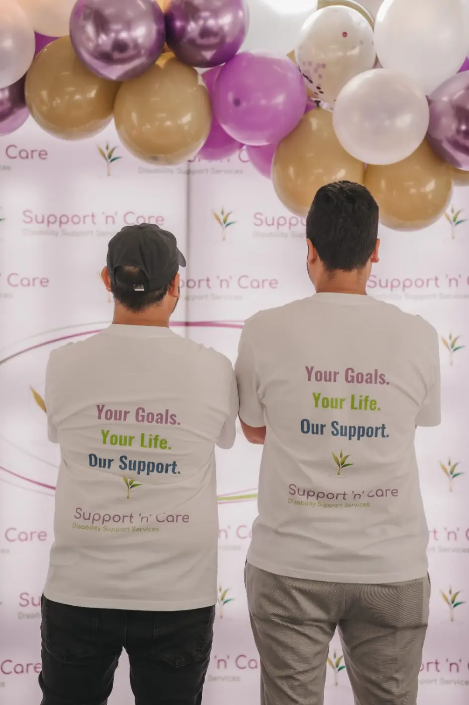 Two team members wearing “Your goals. Your life. Our support.” T-shirts