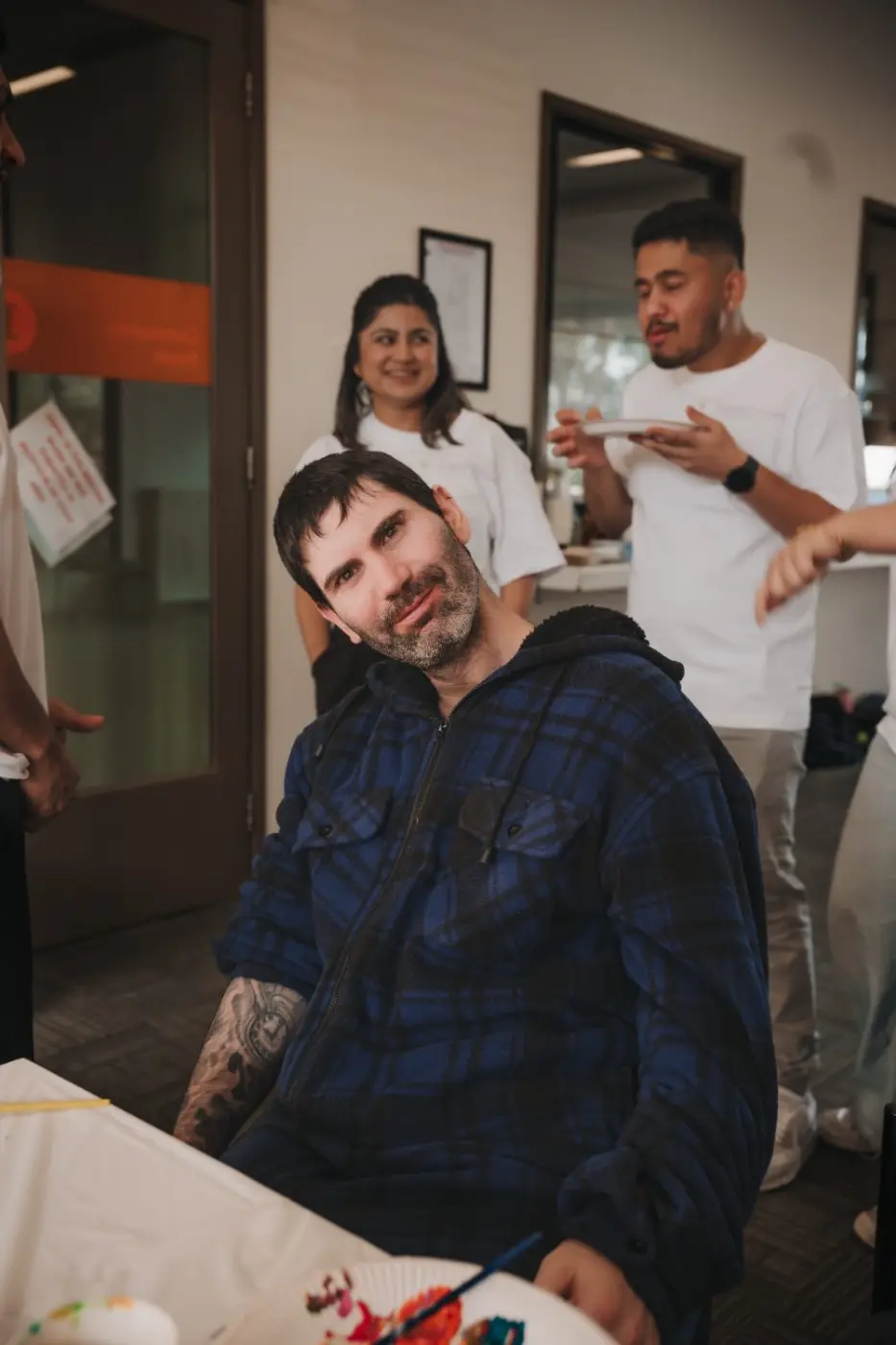 Participant relaxing at a group activity with staff nearby