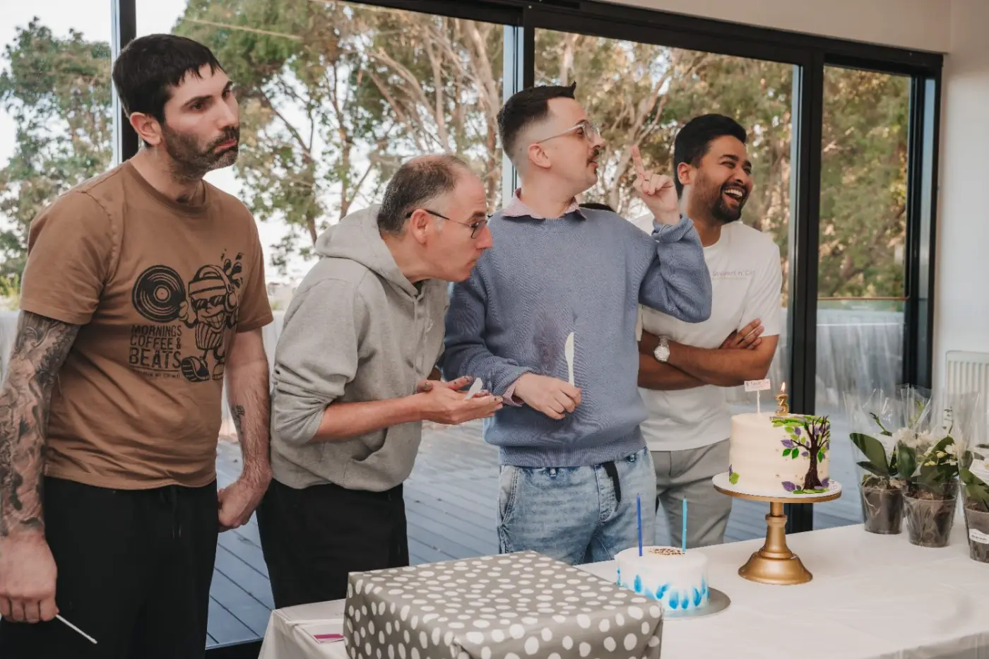 Participants and team members celebrating together around a cake