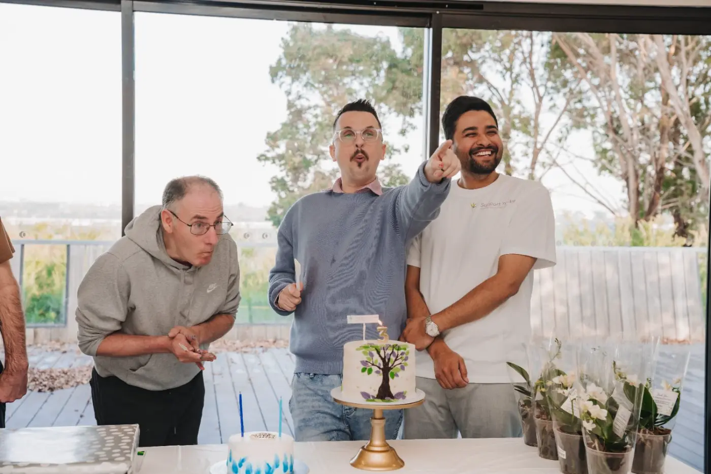 Team members celebrating with a participant around a cake