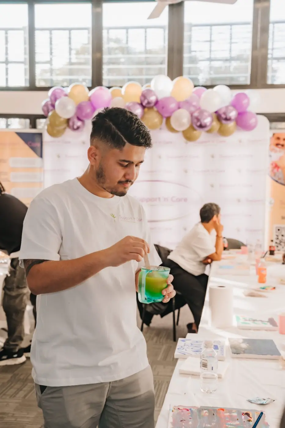 Team member at a community event with balloons in the background