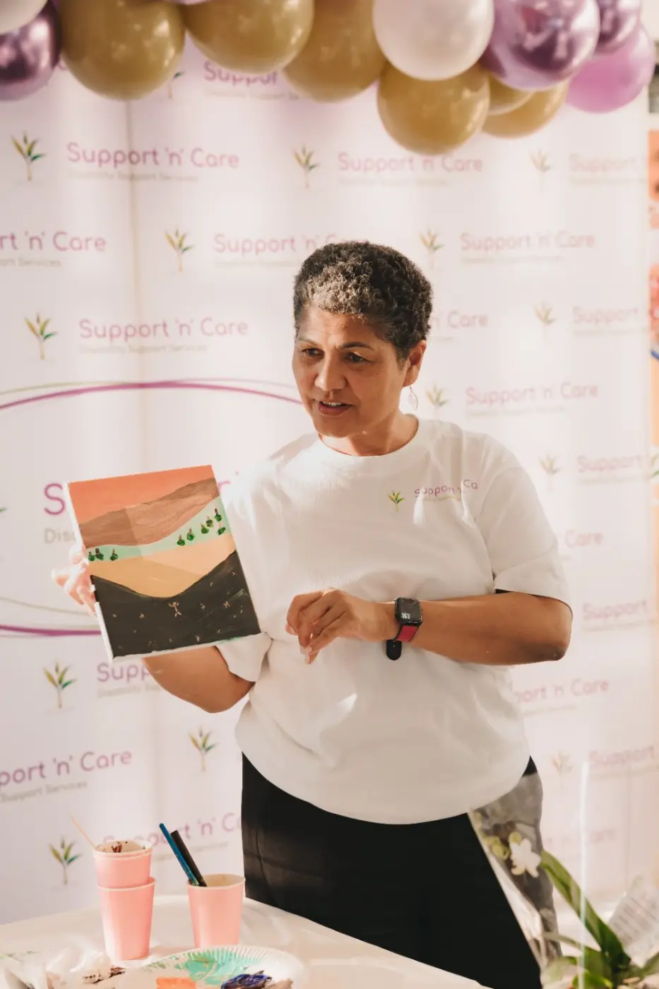 Team member holding up a painted canvas