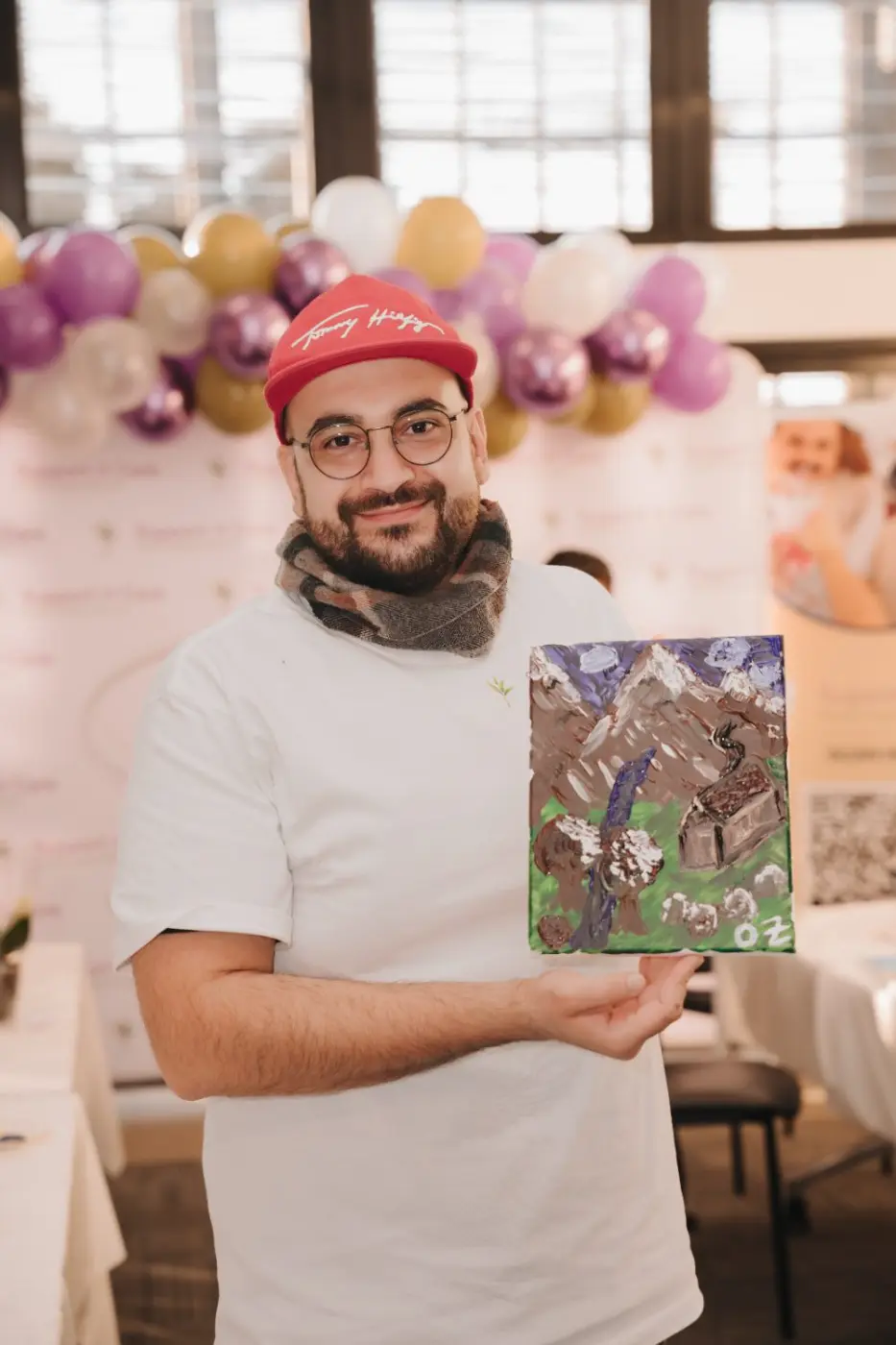 Team member proudly holding up a painting