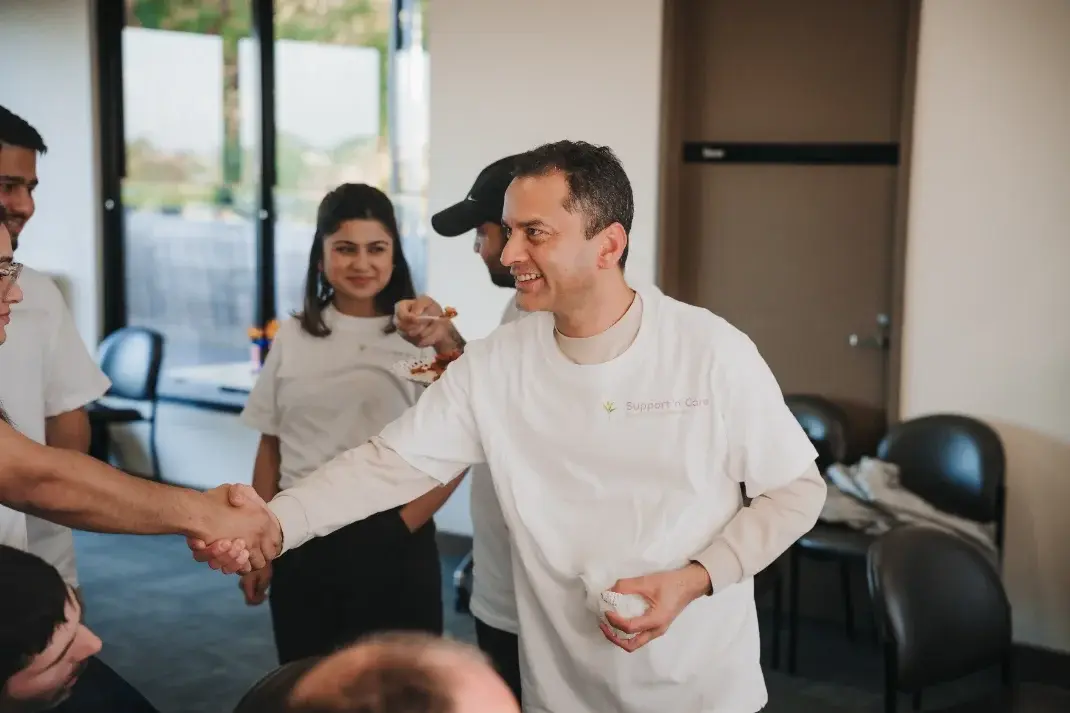 Support worker greeting a participant with a handshake