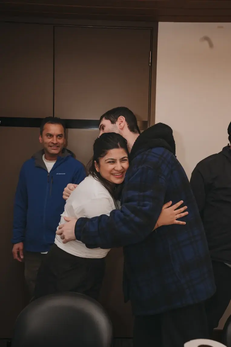 Participant and team member sharing a warm hug